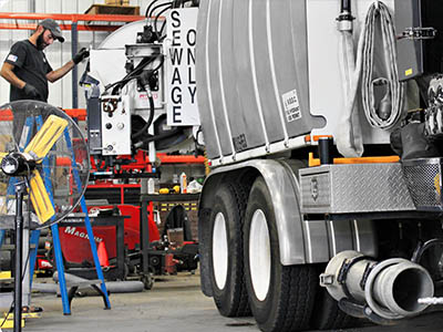 Technician repairing a sewer vac truck