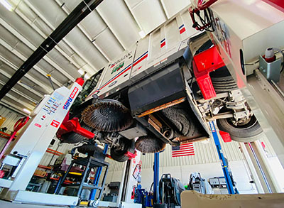 A street sweeper raised on lifts for repair